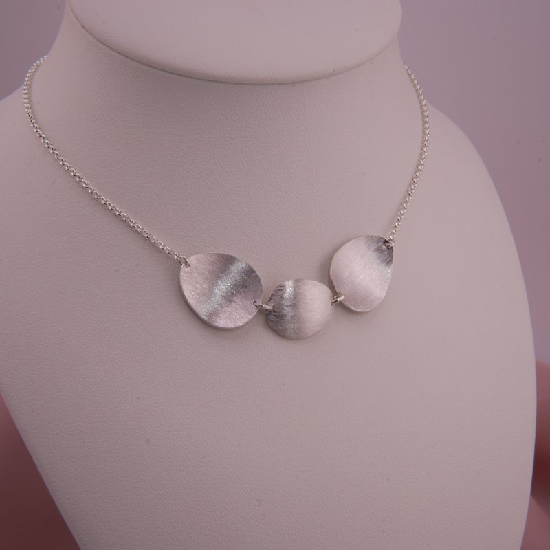 Preview: Das Isola Silber-Collier auf einer Schmuckbüste präsentiert mit der ersten Trage-Option (mittiges Plättchen konkav).